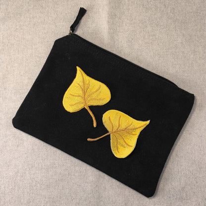 Zwei Stück Pappel Blatt Aufnäher zum aufbügeln auf einem schwarzen Etui als Beispiel auf einem neutralen Hintergrund
