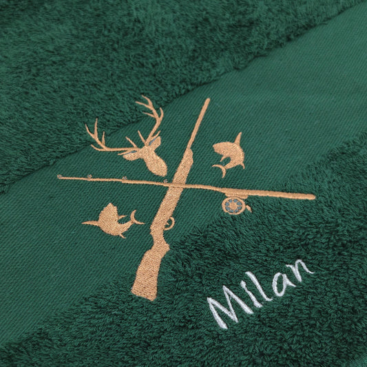 Nahaufnahme der Jagd und Angeln Motiv mit Namen Stickerei um die Qualität zu zeigen. Die Stickerei ist auf einem dunkelgrünen Handtuch angefertigt.
