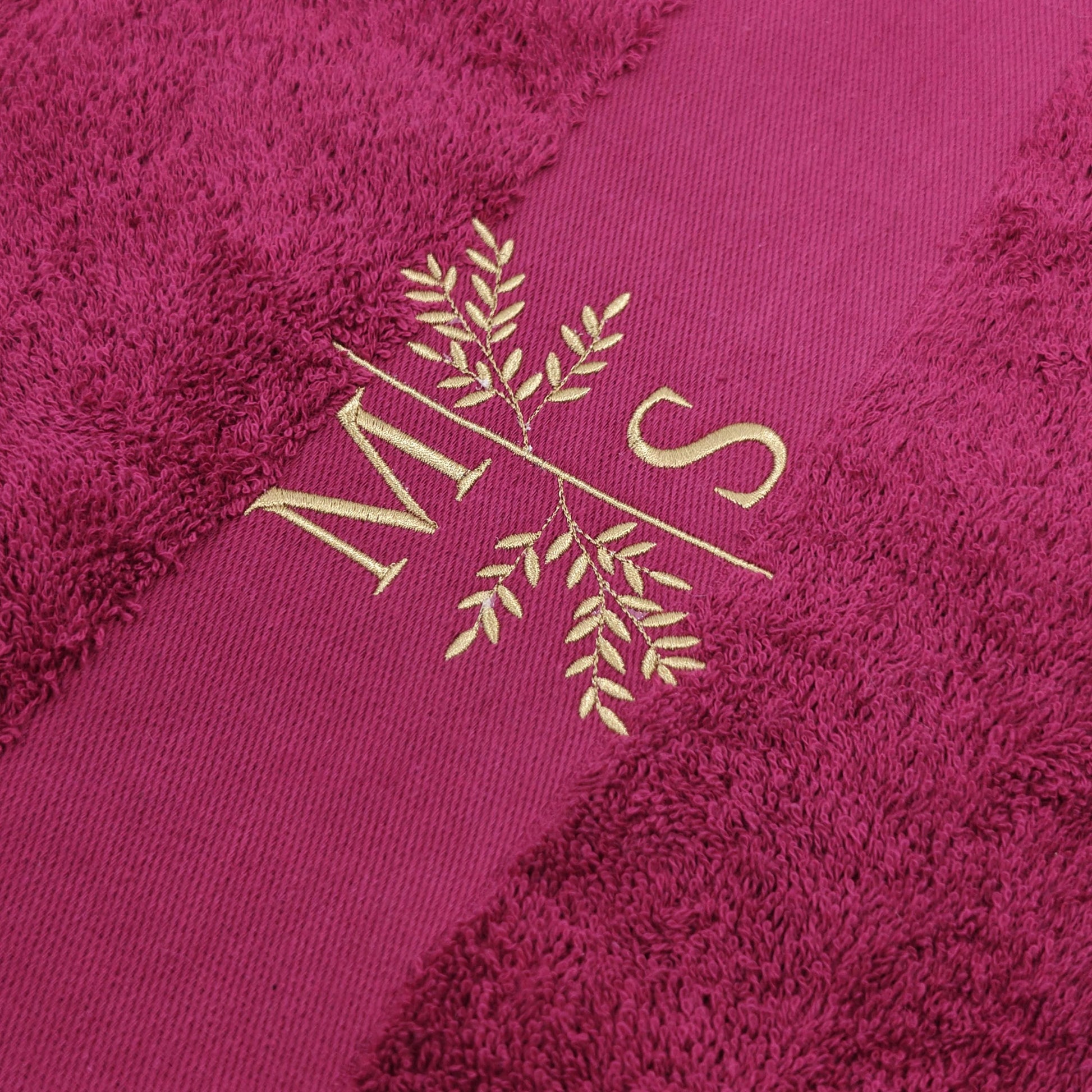 Detail Stickerei Initialen mit Blumenmotiv auf personalisiertem pinkem Handtuch
